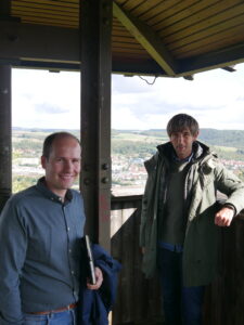 Zwei Männer stehen auf einem Aussichtsturm über der Stadt