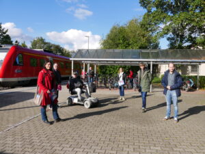 Eine Gruppe von Menschen steht an einem Bahnsteig